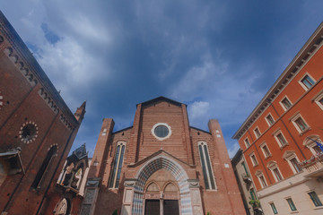 Facade and front entrance of Santa Anastasia Church under blue sky, in Verona, Italy