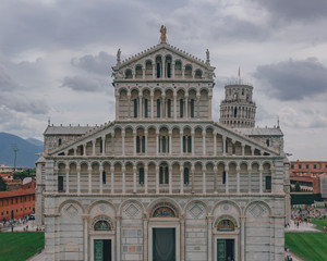 Fototapeta na wymiar Frontal view of the facade of the Pisa Cathedral with the Leaning Tower of Pisa in the back, in Pisa, Italy
