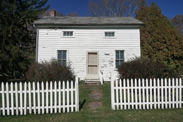 Warren County, New Jersey, USA: An abandoned 19th-century white wooden cottage with white picket...