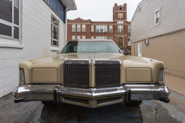 Front of a classic seventies car between vintage buildings