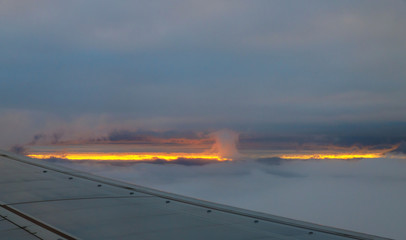 Fototapeta na wymiar Airplane in the sky at sunrise Flying in the of clouds.