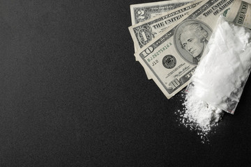Flat lay composition with cocaine and money on dark background. Space for text