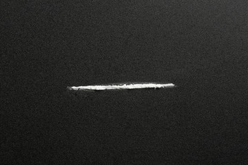 Line of cocaine on dark background, top view