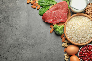 Set of natural food high in protein and space for text on grey background, top view