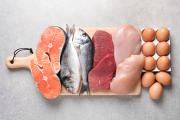 Satz natürlicher Lebensmittel mit hohem Proteingehalt auf grauem Hintergrund, Ansicht von oben