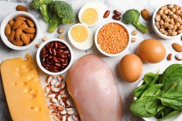 Set of natural food high in protein on marble background, top view