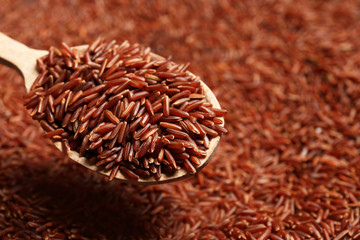 Brown rice in wooden spoon, closeup view