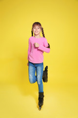 Girl with inline roller skates on color background
