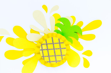 Yellow pineapple with sprinkles made of paper. White background.