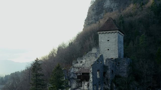 Impressive fortress and broken walls of the old medieval castle stand below the hill.