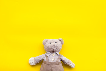 Craft toys for kids. Handmade teddy bear. Yellow background top view mock up