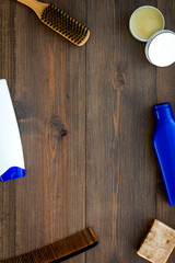Instruments of male hairdresser with shampoo and comb in barbershop top view on wooden background mock up