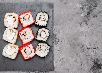 Japanese sushi rolls on stone background.
