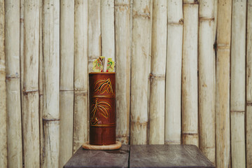  wooden goblet with an umbrella on the bamboo wall background