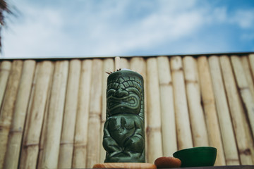 Tiki glass on the background of the sky and the wall of bamboo