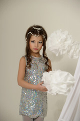 Little girl in a silver dress. Caucasian, attractive.