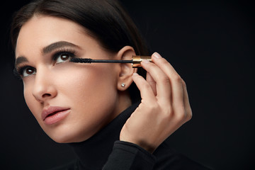 Obraz premium Mascara Makeup. Beauty Model Putting Black Mascara On Eyelashes