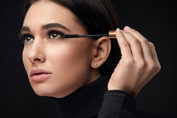 Obraz premium Mascara Makeup. Beauty Model Putting Black Mascara On Eyelashes