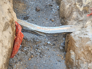 Pipe and cables in trench at road crossing laying pipelines.