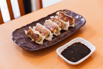 Gyoza (Japanese Pan-Fried Dumplings) served with sauce and sesame oil.