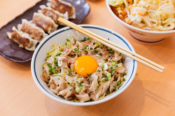 Butadon: Japanese rice bowl dish consisting of pork and onion simmered together and served over rice. Topping with yolk.  