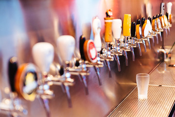 Frozen beer glass with beer taps with nobody. Selective focus. Alcohol concept. Vintage style. Beer...