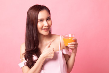 Young Asian woman thumb up with  orange juice