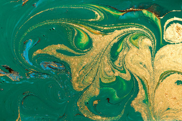 Gold marbling texture design. Green and golden marble pattern. Fluid art.