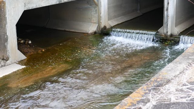 Stream of water flowing through a concrete channel on a windy day in Anniston, Alabama, USA
