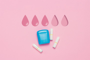 Feminine hygiene tampons and box for shipping and storage on a pink background. Concept of feminine hygiene during menstruation. Added drop mark, absorption level. Three drops. Flat lay, top view