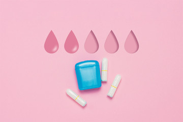 Feminine hygiene tampons and box for shipping and storage on a pink background. Concept of feminine hygiene during menstruation. Added drop mark, absorption level. Two drops. Flat lay, top view