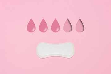 Feminine hygiene pad on a pink background. Concept of feminine hygiene during menstruation. Added drop mark, absorption level. three drops. Flat lay, top view