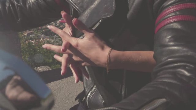 Close-up of couple in love on motorcycle. Stock. Close-up of women's hands clutched in castle embrace motorcyclist. Romantic trip on motorcycle