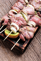 Raw spicy beef shish kebab on a cutting board
