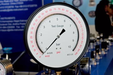 Pressure gauge, manometer on a blurry industrial background.