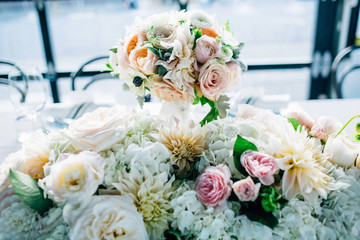 large wedding flower arrangement on table with window light
