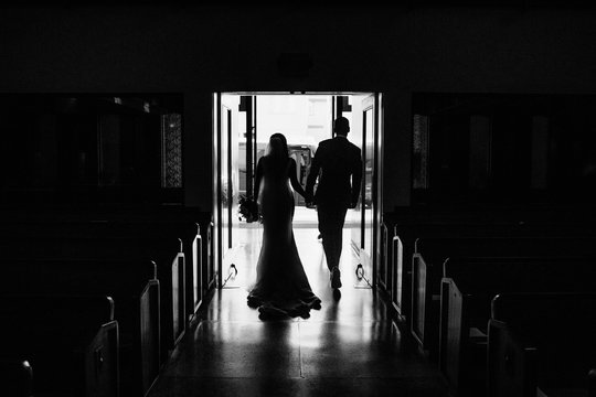 Bride And Groom Walking Down Church Aisle After Ceremony In Black And White