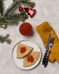 Pancakes with red caviar at white plate with fir tree and Christmas toy