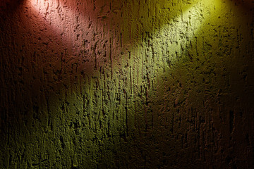 Two beams of pink and yellow color cross over a textural background