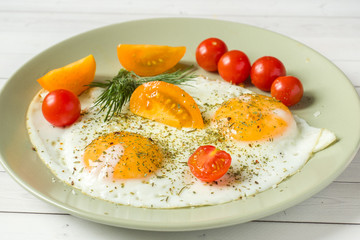 Fried eggs with cherry tomatoes on a plate