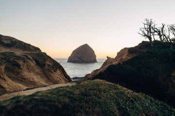 large rock at beach during sunset