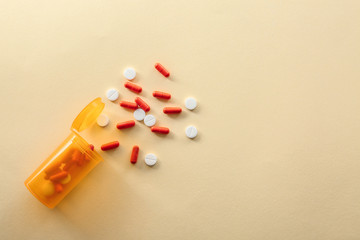 Container with pills on color background