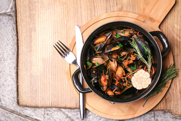 Tasty mussels in pot on table