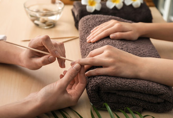 Young woman getting manicure in beauty salon - obrazy, fototapety, plakaty