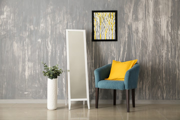 Beautiful interior of comfortable living room with armchair and mirror