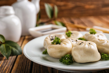 Plate with tasty Chinese dumplings on table, closeup