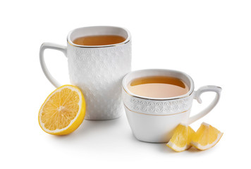 Cups of hot tea and lemon on white background