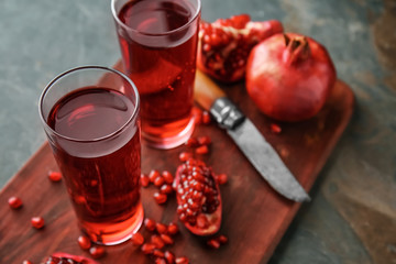 Glasses of tasty pomegranate juice on table