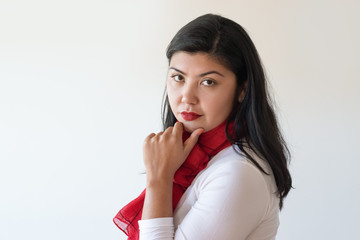 Closeup of pensive young woman thinking and posing. Side view of serious Asian girl touching chin and looking at camera. Female portrait concept