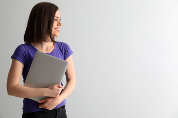 Young woman with laptop on white background